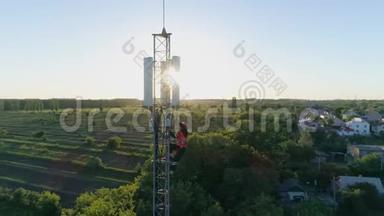维修工人利用日落背景下的安全设备对通信塔进行高水平维修