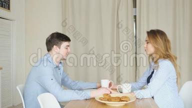 一对夫妇坐在<strong>桌子</strong>上，手牵手在<strong>早餐</strong>前祈祷