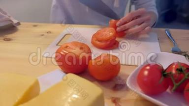 女人在<strong>塑料板</strong>上切西红柿，双手特写。