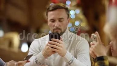 男人、女人和小男孩在圣诞满桌的智能手机<strong>上上</strong>网，特写镜头