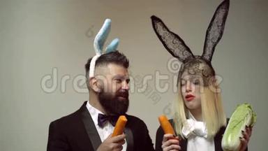 兔子夫妇吃胡萝卜。 兔子耳朵概念与兔子夫妇。 活泼的复活节夫妇。 兔子男女惊喜