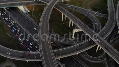 空中无人机观高速公路多层次连接道路与移动汽车在日落。 汽车正在多层公路上行驶
