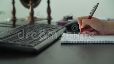 年轻女子写一些笔记和电脑打字
