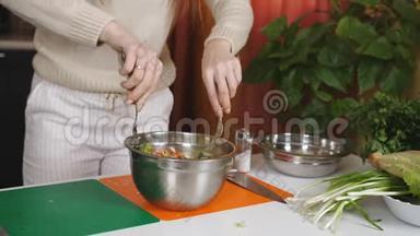 女人把蔬菜沙拉拌在碗餐具里。 混合素食沙拉的成分。 蔬菜沙拉的准备..