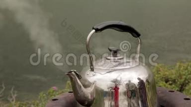 铁壶正在一座山湖的岸边沸腾.. 野营钳