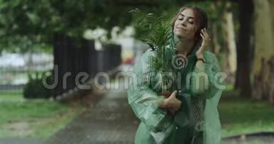 特写美女带着一朵花在下雨天走在街上，听着耳机里的音乐。