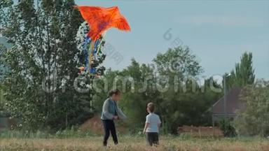后景孩子玩风筝，一个<strong>小女孩</strong>和一个男孩让一条飞蛇在<strong>草地上</strong>。 快乐和无忧无虑