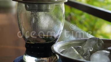 顾客喝冰茶时，在咖啡厅用越南传统的phin过滤器冲泡黑咖啡。 咖啡点滴
