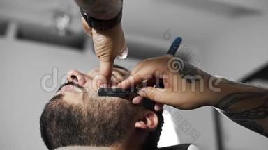 理发师用直剃须刀刮顾客，在理发店`理发和刮胡子