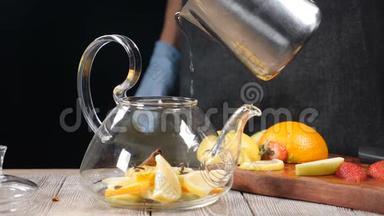 将热水倒入茶壶中，放入<strong>切好的水果</strong>. 玻璃茶壶里面有橘子和柠檬。 茶<strong>的</strong>酿造慢动作。 热辣