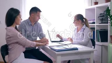 年轻的<strong>家庭</strong>医生，一位医生咨询一对夫妇坐在医疗办公室的办公桌前的<strong>生育</strong>率