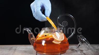 做<strong>水果茶</strong>。 酒保把一片橘子放进沸腾的茶壶里，里面有不同的<strong>水</strong>果。 慢动作