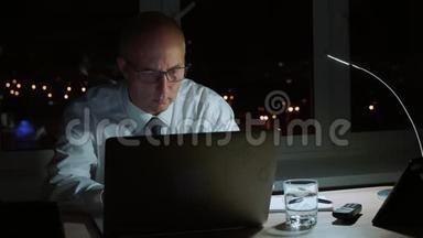 执行职业经理人在深夜微笑着用笔记本电脑工作