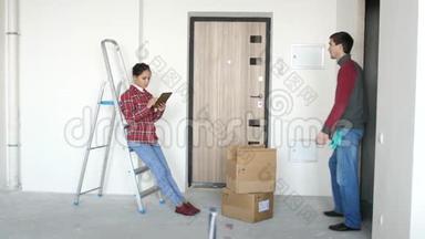 年轻女子站在梯子旁，在空荡荡的房间里喊着丈夫，然后他们选择了平板电脑上的设计