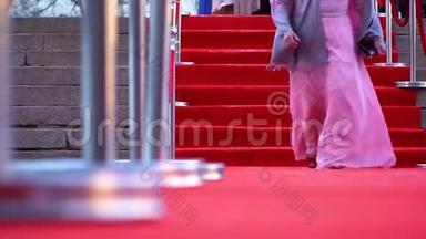 一个穿着<strong>粉色</strong>裙子走在红<strong>地毯</strong>上的女演员，特写