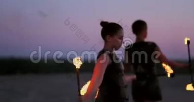 职业舞蹈家妇女在节日里用燃烧的闪闪发光的火把进行火秀和烟火表演。