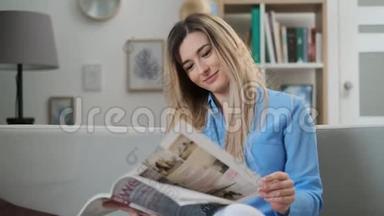 年轻女子在家阅读杂志的肖像。 坐在时尚杂志上<strong>翻页</strong>的迷人女孩