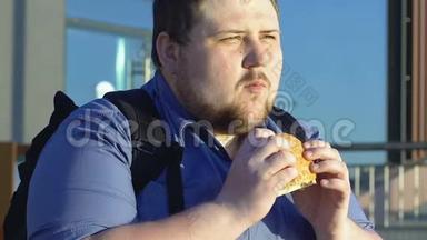 肥胖男学生在户外吃高<strong>热量</strong>汉堡、快餐和超重