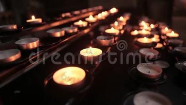 在暮色中在寺庙里点燃蜡烛。 燃烧教堂蜡烛