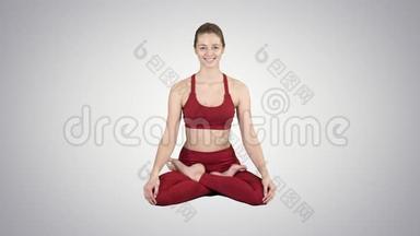 年轻<strong>微笑</strong>的女人练习<strong>瑜伽</strong>，<strong>做</strong>帕德马萨纳运动，莲花姿势在梯度背景。
