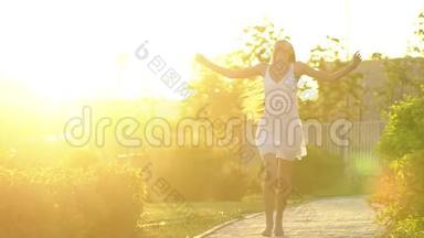 美丽的女孩在绿色公园的夏日里，在夕阳下<strong>奔跑</strong>着玩。 <strong>自由</strong>，健康，幸福的理念.. 快乐