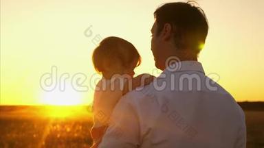 爸爸和小孩子一起散步，在傍晚的公园里，日落时分。 爸爸和女儿一起放假一天..