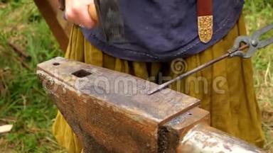 铁匠在铁匠铺的铁砧上手工锻造熔化的金属。