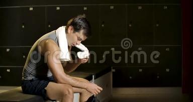 一个人在健身或锻炼后独自在健身房更衣室休息的肖像。