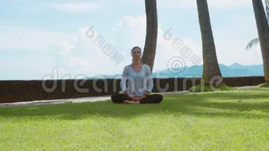 快乐女人莲花式瑜伽练习，在巴厘岛的海边伸展，优美的背景和自然的声音