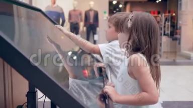 现代小男孩与女孩使用触摸屏的自助服务机搜索有关大厅和地点的信息