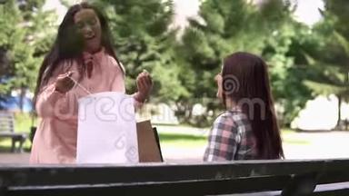 购物后的女孩跑到她的朋友面前，在包裹里展示她的购物。 慢动作。 <strong>高清高清</strong>