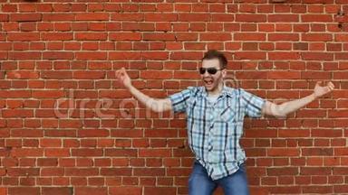 快乐的小胡子舞蹈男。 积极的人类情感，砖墙背景