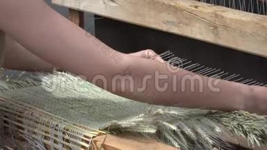 户外集市中，女人用复古手工织布机编织地毯垫。4公里