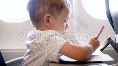 4k特写镜头可爱的2岁幼儿男孩在<strong>飞机</strong>上用彩色铅笔<strong>画画</strong>