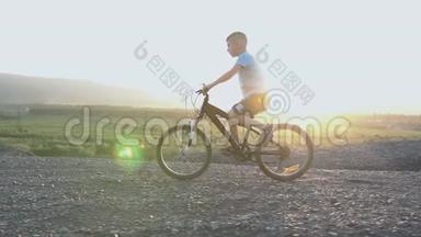 小<strong>男</strong>孩骑自行车在<strong>夏季</strong>山顶美丽的日落天空背景。 八岁的白种人小<strong>男</strong>孩