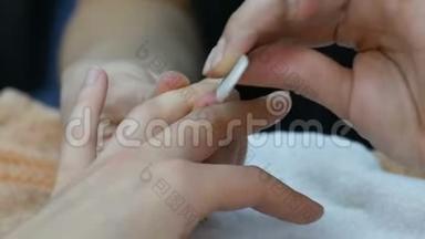 在美容师做美甲的女人。 指甲在美容师里锯女人。 手部和指甲护理