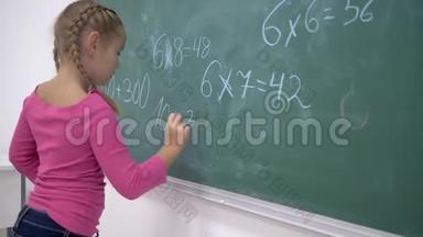 小学教育，女生用粉笔在<strong>班级</strong>绿色黑板上解决数学问题