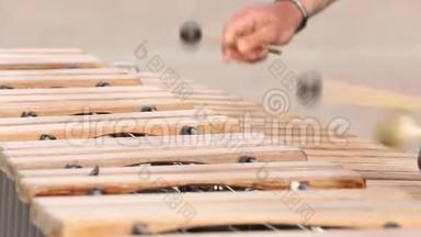 一个穿着黑色T恤的街头<strong>音乐</strong>家正在演奏木琴..