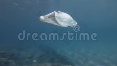 塑料污染，蓝色水中白色塑料袋。 慢动作，被丢弃的塑料袋慢慢地飘到蓝色的水面下