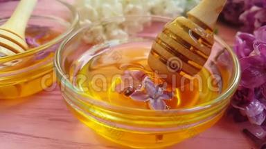 蜂蜜有机天然浇注美味的丁香花，木制背景，美味