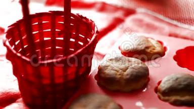女人把新鲜的松饼放在红色的篮子里