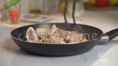 在电炉上煎锅里煎肉.. 女人在电炉上的煎锅里混合炒肉