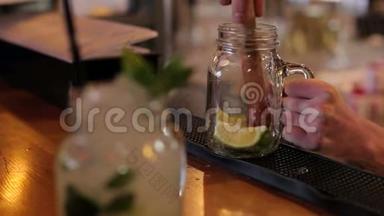 酒保用勺子捏柠檬汁，在酒吧的特写镜头里煮莫吉托