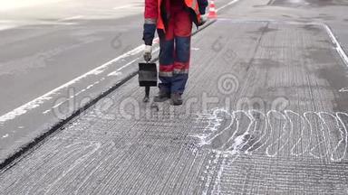 修路。 工作细节，工人浇筑树脂路面覆盖沥青..