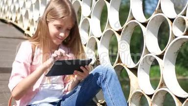 在公园<strong>玩</strong>平板电脑，小女孩在大自然中使用<strong>户外</strong>智能<strong>手机</strong>