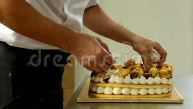 糖果师用金色糖果装饰美味的奶油蛋糕。