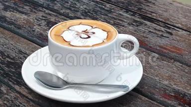 风味咖啡在白色的杯子里<strong>放</strong>在盘子里，用勺子<strong>放</strong>在木制的乡村<strong>桌子上</strong>，波浪运动。 喝着海景咖啡