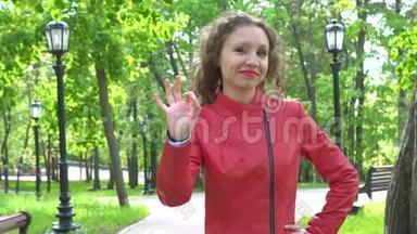穿着红色<strong>皮夹克</strong>的年轻女子挥手示意绿园