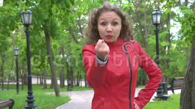 愤怒的愤怒的愤怒的愤怒的女孩穿着红色的皮夹克，在空中挥舞着拳头