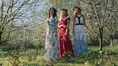 年轻漂亮的女人穿着长裙在春天的树间开花。